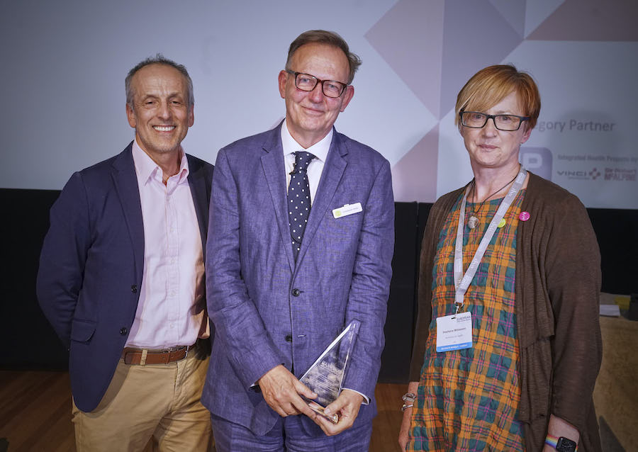 Christopher Shaw (centre), winner of the Susan Francis Design Champion Award, with Alan Kondys of lead awards partner IHP, and Stephanie Williamson, co-chair of Architects for Health - 